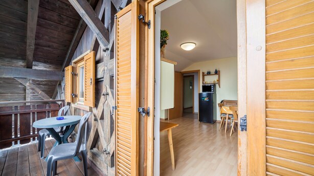 Un interior de madera con comedor, cocina y vistas al exterior.