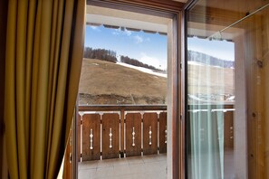A balcony with a wooden railing and a view of a snowy landscape. - Apartment 'Chalet Anna Cigambola' with Mountain View, Balcony and Wi-Fi (Livigno)