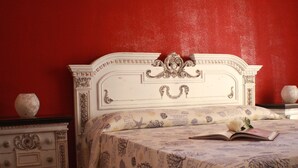 A bed with a patterned bedspread, a book, and a vase on a nightstand. - Apartment 'Il Fosso' with Sea View, Wi-Fi (Borghetto Santo Spirito)
