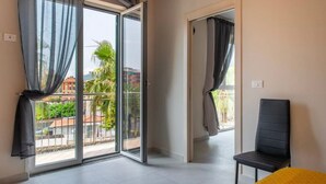 Een kamer met balkon, een stoel en een bed.