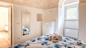Un dormitorio con cama, cómoda, espejo, ventana y puerta.