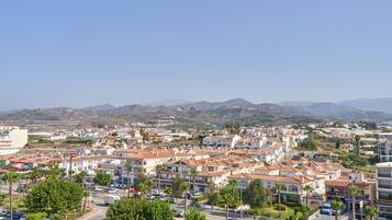 A residential area with houses, roads, and distant mountains.