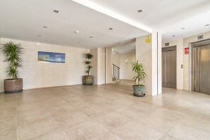 A spacious lobby with tiled floors, potted plants, a painting, and an elevator. - Studio Apartment "Great Sea Views Studio A68" near Beach with Shared Pool & Wi-Fi (Torrox)