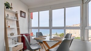 A dining area with a table, chairs, and a view of the sea through large windows. - Studio Apartment "Great Sea Views Studio A68" near Beach with Shared Pool & Wi-Fi (Torrox)
