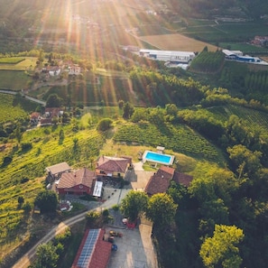 Vista aérea de un viñedo con edificios, una piscina y un panel solar.
