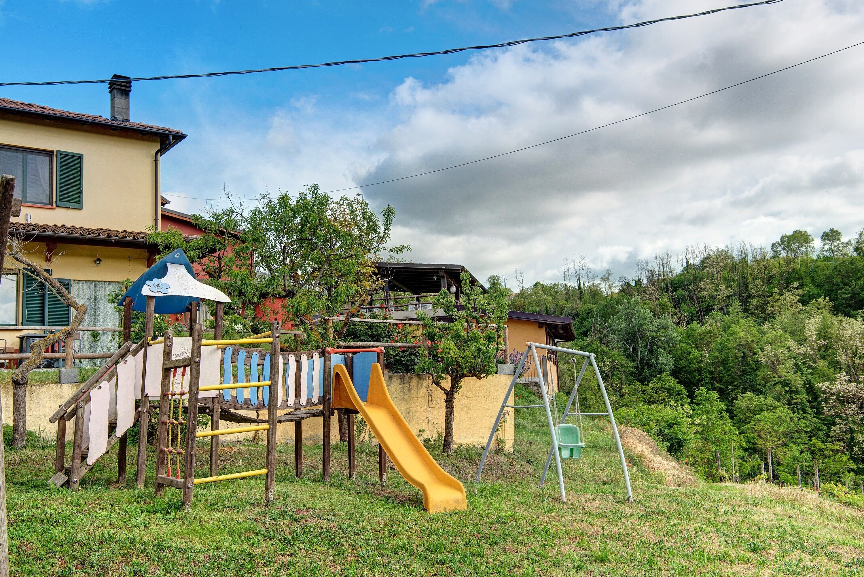 A playground with a slide, climbing area, and swing set.