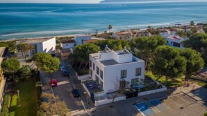 Un quartier résidentiel situé sur la côte, avec des maisons modernes, une vue dégagée sur la mer et un parking.