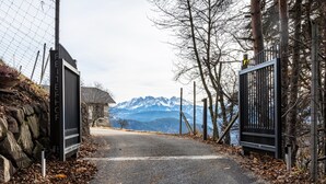 A road leading to a gate with a mountainous backdrop. - Apartment "Reiterhof Gaia" with Mountain View, Private Garden & Wi-Fi (San Genesio Atesino)