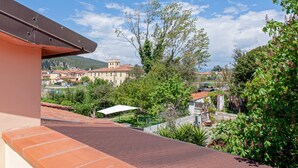 Une terrasse offrant une vue sur un quartier résidentiel, avec des maisons et une tour.