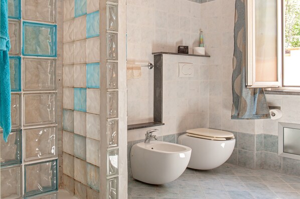 Une salle de bain avec deux bidet, un porte-serviettes et un miroir.