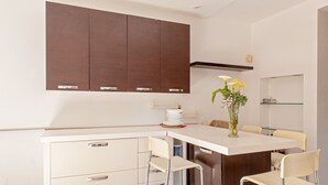 Une cuisine moderne avec un îlot central, des tabourets de bar et un vase rempli de fleurs.