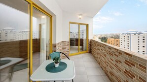 A balcony with a table, chair, and potted plant. - Holiday Apartment "Karol Vaz" with Balcony, Shared Pool & Wi-Fi (Portimão)