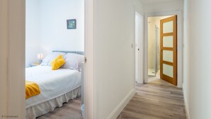 A hotel room with a bed, a nightstand, and a picture on the wall.