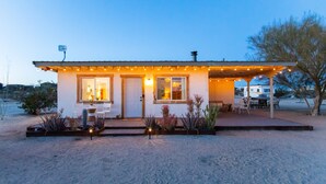 Ein kleines, eingeschossiges Haus mit überdachter Veranda und Lichterkette.