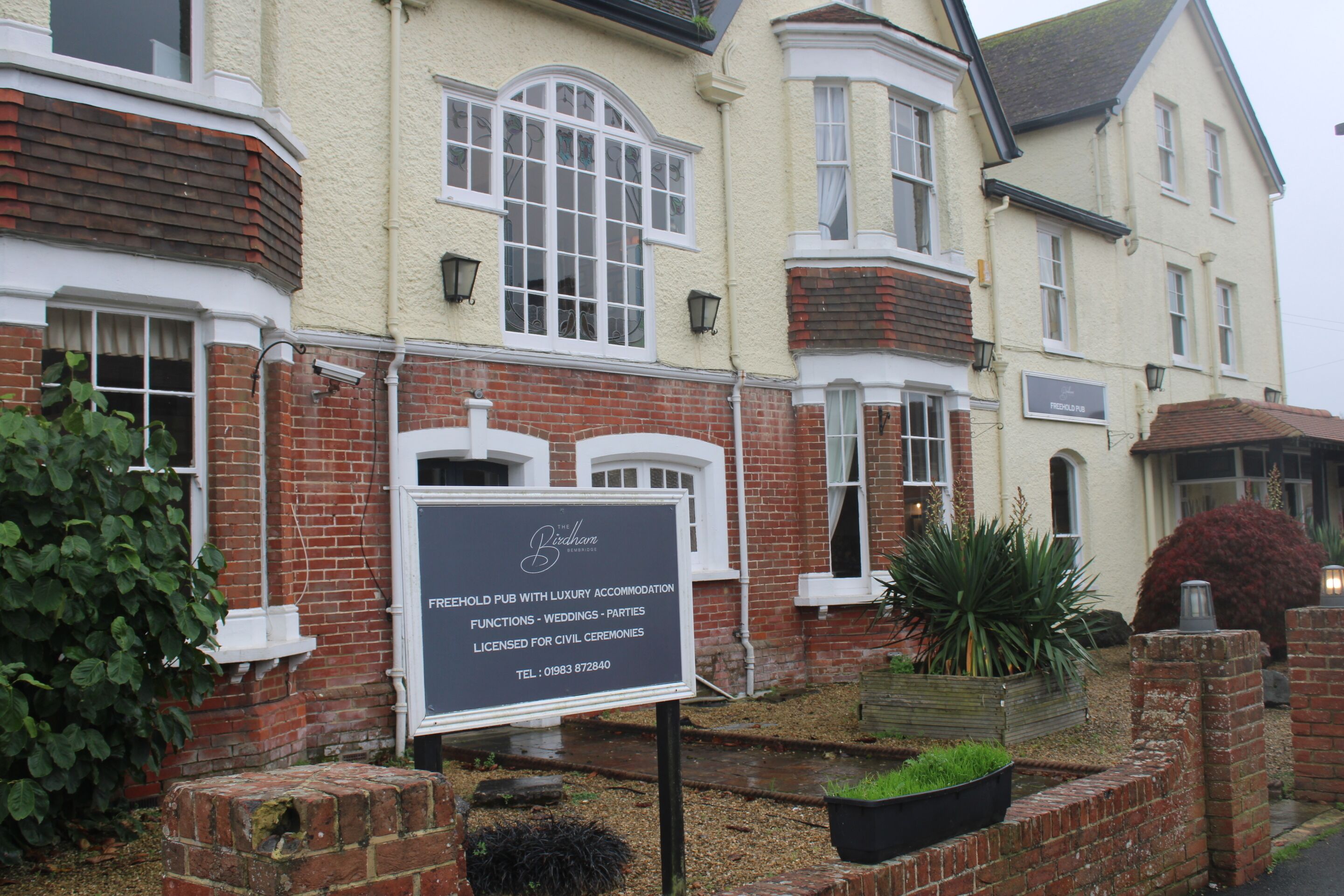 A building with a sign indicating it is a pub with luxury accommodation, functions, weddings, parties, and civil ceremonies.