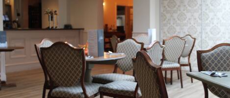 A dining area with patterned upholstered chairs and a round table.