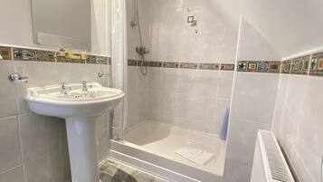 Ein Badezimmer mit einem Standwaschbecken, einer Dusche und einer Badewanne.