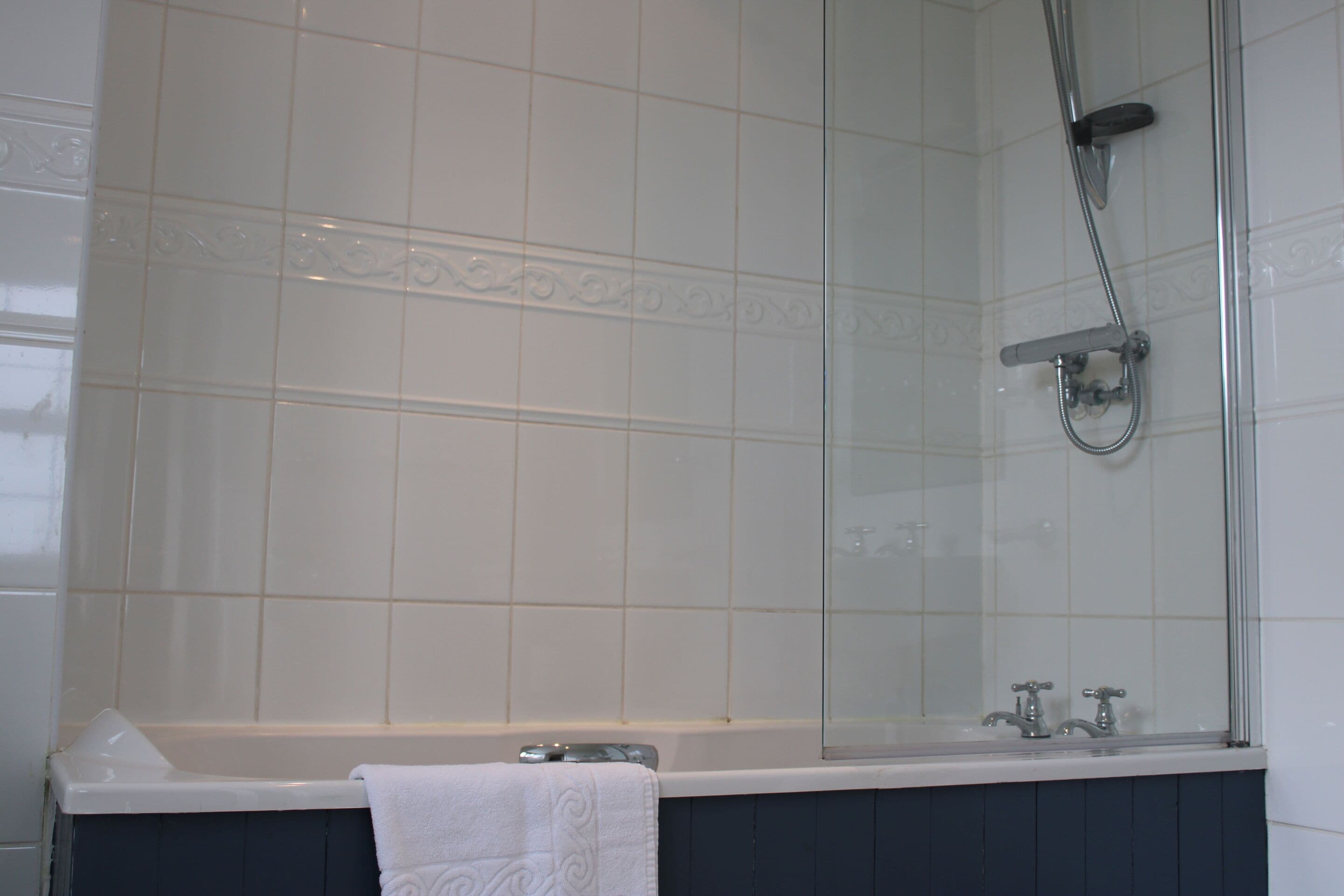 Un bagno con una vasca, una doccia e uno specchio.