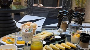 A breakfast buffet with various dishes, a fireplace, and decorative elements in the background. - Riad Dar Chrifa (Rabat)