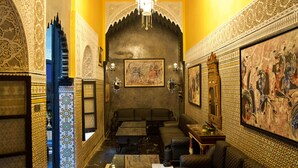 A traditional interior with ornate tile work, a chandelier, and a seating area with sofas and tables. - Riad Dar Chrifa (Rabat)