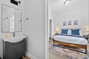 Relax in this serene bedroom with a large bed, vanity, and wall-mounted lamps.