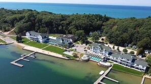 An aerial view of a coastal property with a large house, a dock, and a marina.