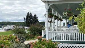 Eine Veranda mit weißen Geländern und hängenden Blumenkörben.