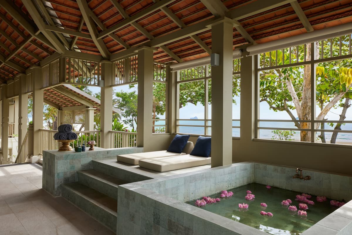 Ein Wellnessbereich mit Pool, Treppen zu einer Sitzgelegenheit und Blick auf das Meer.