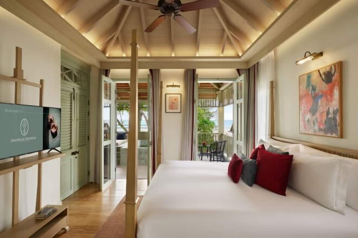 Ein Hotelzimmer mit einem Bett, einem Fernseher, einem Deckenventilator und Blick ins Freie.