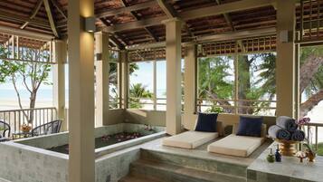 Relax in a serene outdoor lounge with tiered seating, a tranquil water feature, and stunning views of the tropical landscape.