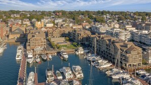 Un port de plaisance où sont amarrés de nombreux bateaux, entouré d’immeubles d’habitation et sous un ciel dégagé.