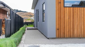 Ein modernes Gebäude mit grauer Fassade und einem Holzbereich.