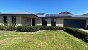 A modern two-story house with a flat roof, solar panels, and a garage. - Sandy Retreat on Royal Inverloch (Inverloch)