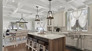 A spacious kitchen with a large island, pendant lights, and a view of the outdoors. - Paradise Bay (Queensbury)