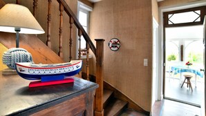 Un escalier en bois, avec une lampe et un modèle de bateau posé sur une table.