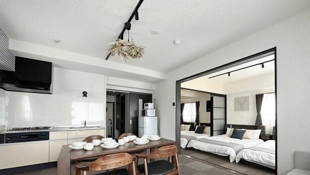 Une chambre d’hôtel moderne dotée d’une kitchenette, d’un coin repas et d’une chambre à coucher avec un grand lit et un canapé.