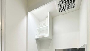 Une petite cuisine équipée comprenant un four à micro-ondes encastré, une cuisinière à gaz et un évier.