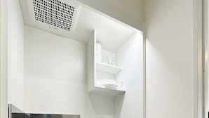 Una kitchenette funcional con microondas, estufa, lavamanos y alacenas.