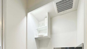 A compact kitchenette with a microwave, a coffee maker, and a sink.