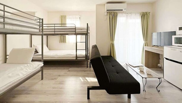 A dormitory room with bunk beds, a desk, a chair, and an air conditioning unit. - 1Br Apt with Balcony for 4 Ppl in Onomichi (Onomichi)