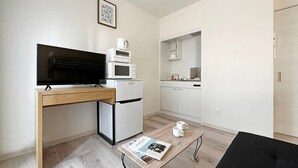 A compact living space with a kitchenette, a flat-screen TV, a small refrigerator, and a coffee machine. - 1Br Apt with Balcony for 4 Ppl in Onomichi (Onomichi)