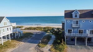 A beachfront property with a large house and a smaller building, both featuring balconies and a clear view of the ocean. - Flamingo Villa - Oceanfront B Luxury Home, Hot Tub, 6 bed 4.5 bath (North Topsail Beach)
