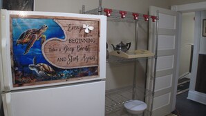 A kitchen with a refrigerator, a shelf with a teapot, and a motivational quote on the fridge. - Light House  , Unique Apartment in the Heart of the city  (Winnipeg)