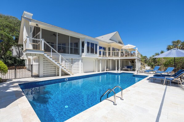A two-story house with a swimming pool, a covered deck, and a staircase leading to the upper level.