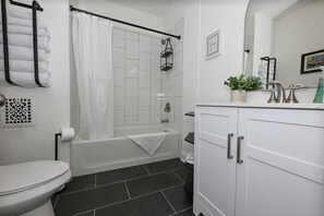 Bathtub, hair dryer, towels, shampoo