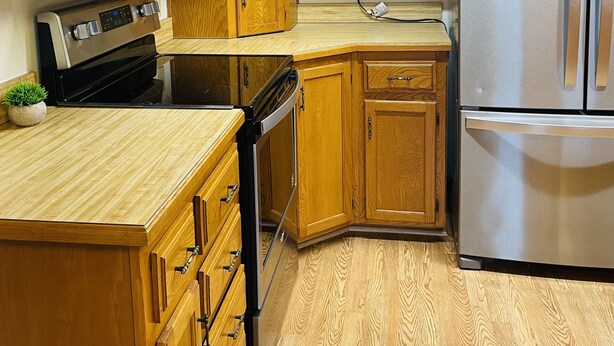 A kitchen with wooden cabinets, a microwave, a stove, a refrigerator, and a dishwasher. -  Home on Quiet Cul de Sac with Handicap Accessibility (Kearney)