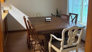 A dining area with a wooden table, chairs, a ceiling fan, and artwork on the wall. -  Home on Quiet Cul de Sac with Handicap Accessibility (Kearney)