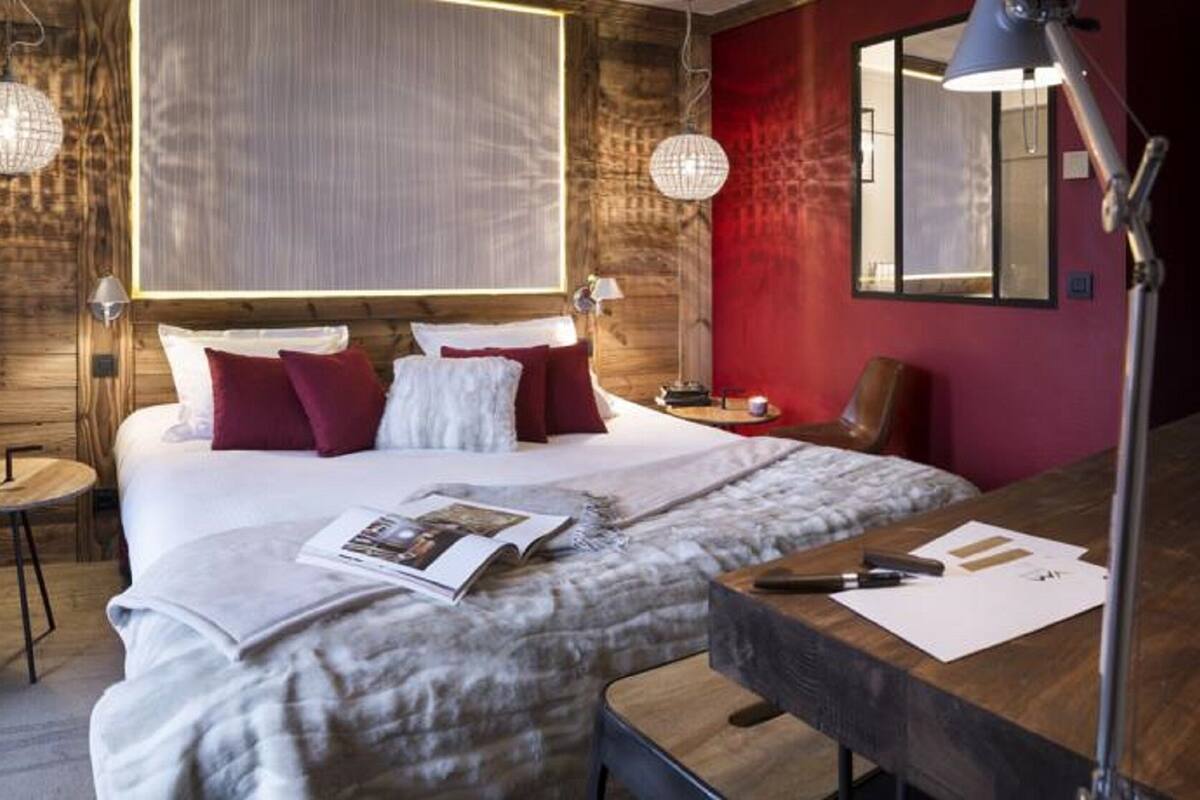 Ein Schlafzimmer mit Bett, Nachttischen, Schreibtisch und Spiegel.