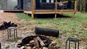 Une cabane dotée d’une terrasse, d’un foyer extérieur et de sièges pour profiter de l’extérieur.