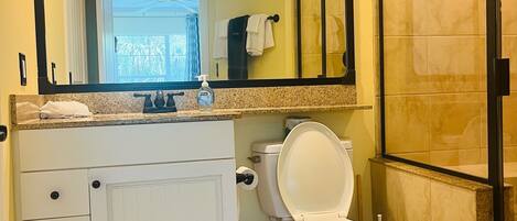 Une salle de bain avec des toilettes, un lavabo et un miroir.